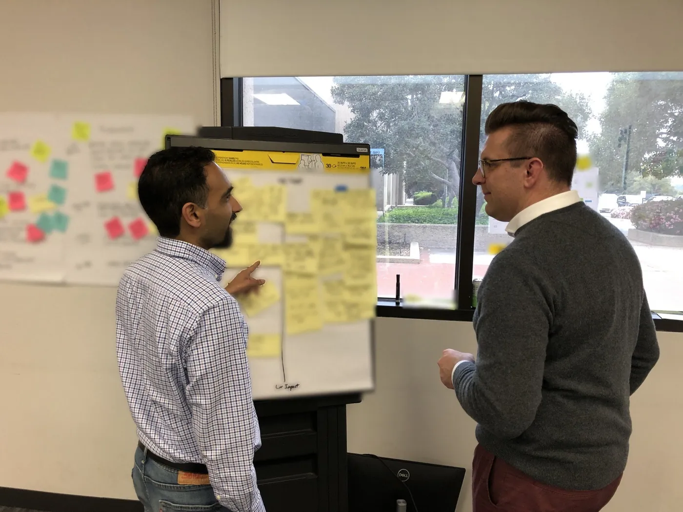 Suken working through priorities with a client at an impact board